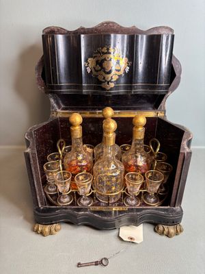 une caisse en bois contenant plusieurs verres et une bouteille