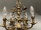 an antique brass chandelier with three light bulbs