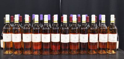Des bouteilles de vin sont alignées sur une table devant un fond noir.
