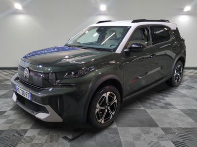 the green suv is parked on a checkered floor in the garage