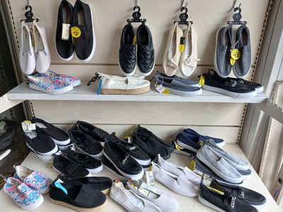 many pairs of shoes that are on a shelf