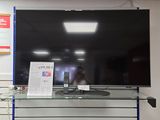 a large flat screen tv sitting on top of a glass shelf