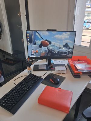 un bureau sur lequel se trouvent un ordinateur, un clavier, une souris et d'autres objets