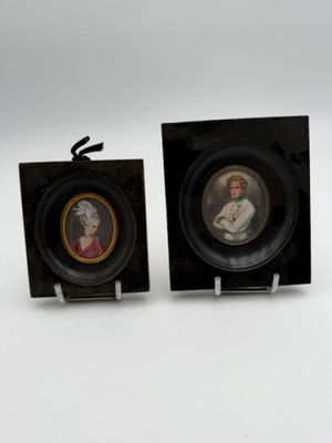 two miniature pictures of a man and a woman in a black frame