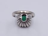 a close up of a ring with a green stone in it