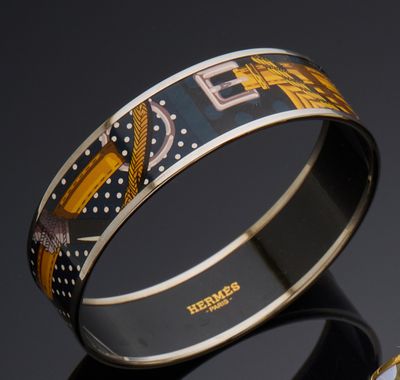 two bangles with designs on them sitting next to each other