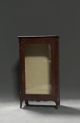 une petite armoire avec une porte vitrée, dans un coin
