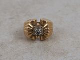 a close up of a gold ring with a diamond in the center
