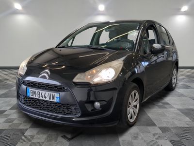 la petite voiture noire est garée sur un sol en damier
