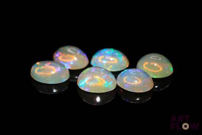 a group of white oplite stones sitting on top of a black surface
