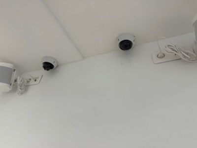 two surveillance cameras on the wall of a room