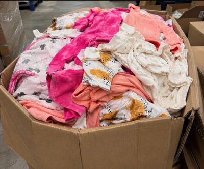 une boîte en carton remplie de nombreux vêtements dans un entrepôt