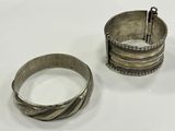 deux bracelets en argent et une bague en argent posés sur une surface blanche
