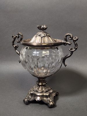 an antique silver plated sugar dish with a glass lid