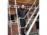 man standing on a scaffolding ladder in front of a brick building