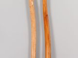pair of wooden baseball bats sitting on top of a white table