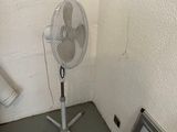 un petit ventilateur dans un coin de la pièce, à côté d'un téléviseur