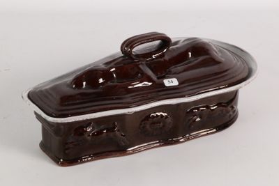 a brown and white ceramic covered dish on a white surface