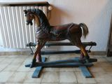 un cheval à bascule en bois posé par terre