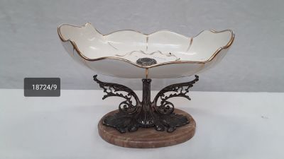 a white bowl that is on a wooden stand
