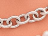 un gros plan sur un collier et deux perles posés sur une table