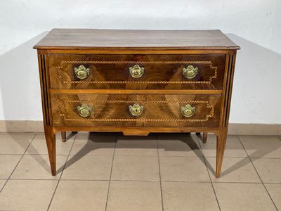 a small wooden chest of drawers on a tiled floor