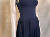 Le mannequin porte une robe bleue à col montant.