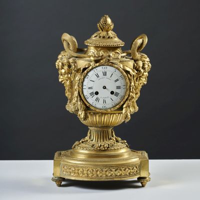 une horloge en or posée sur une table blanche