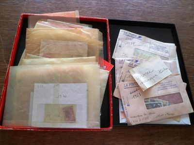 une boîte rouge remplie d'enveloppes et de timbres posée sur une table