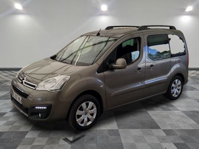 La petite camionnette est garée dans une grande pièce au sol carrelé en damier.