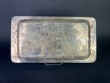 a close up of a metal tray with a handle on a black surface
