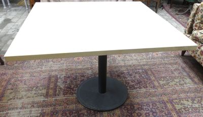 une table blanche avec un piètement noir dans une pièce