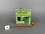 a small green building with a sign on the front of it