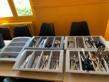 Plusieurs plateaux d'argenterie sont posés sur une table devant une fenêtre