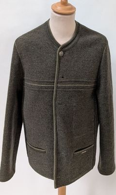 veste en laine grise posée sur un présentoir pour mannequin