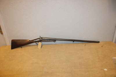 un fusil posé sur une table près d'un mur