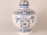 a blue and white vase with a lid sitting on a table