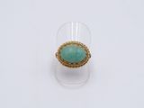 une image représentant une bague en or sertie d'une pierre turquoise