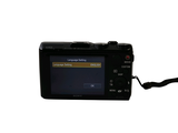 a digital camera that is sitting on a white surface