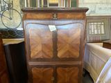 une armoire en bois surmontée d'un miroir, dans une pièce