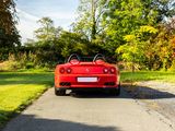 a red sports car that is parked on the side of the road