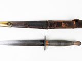 two knives are laying next to each other on a white surface