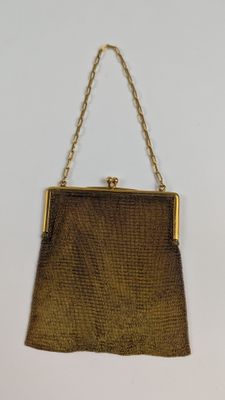 un sac à main marron avec une chaîne qui pend sur le côté