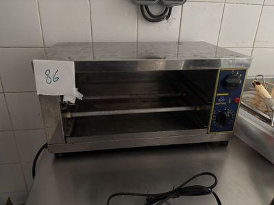 un four grille-pain posé sur un plan de travail, avec une étiquette de prix dessus