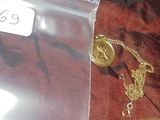 un collier en or avec une chaîne posé sur un tissu rouge