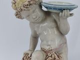 a statue of a boy with a bowl on his head