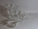 un vase en verre et d'autres objets en verre posés sur une surface blanche