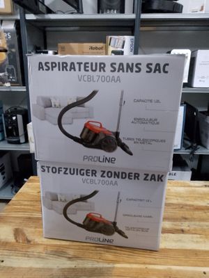 deux cartons contenant des aspirateurs posés sur une table en bois