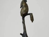 sculpture en bronze représentant un oiseau perché sur une branche d'arbre