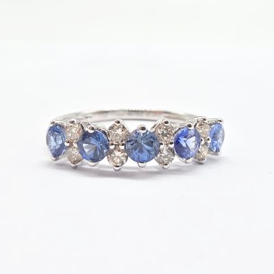 gros plan d'une bague en diamant bleu et blanc sur une surface blanche